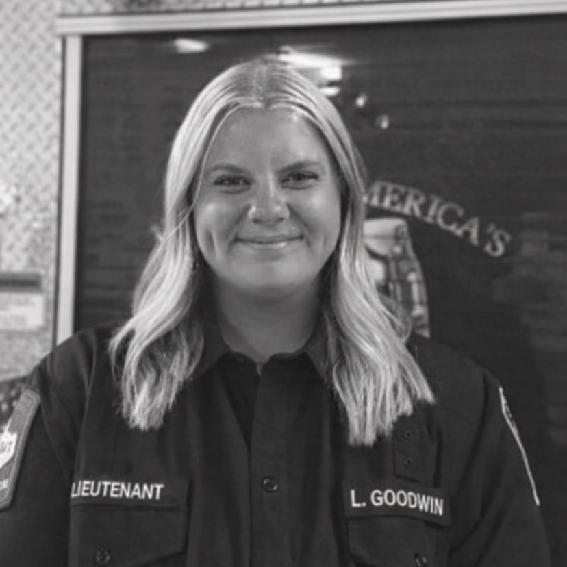 Black and White picture of a Firefighter Lieutenant in front of a fire engine